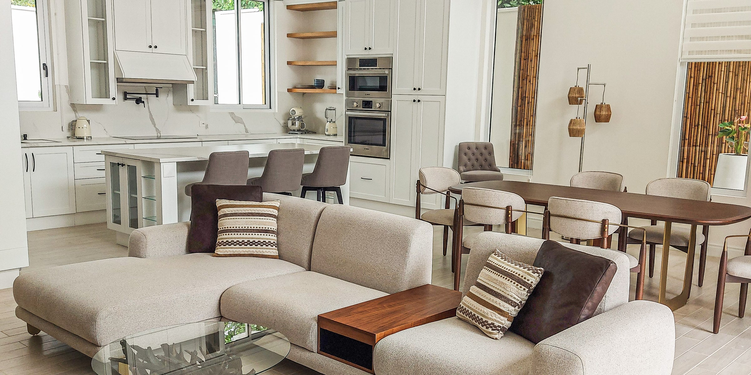 Open living room with a cream sectional sofa beside the kitchen and dining area