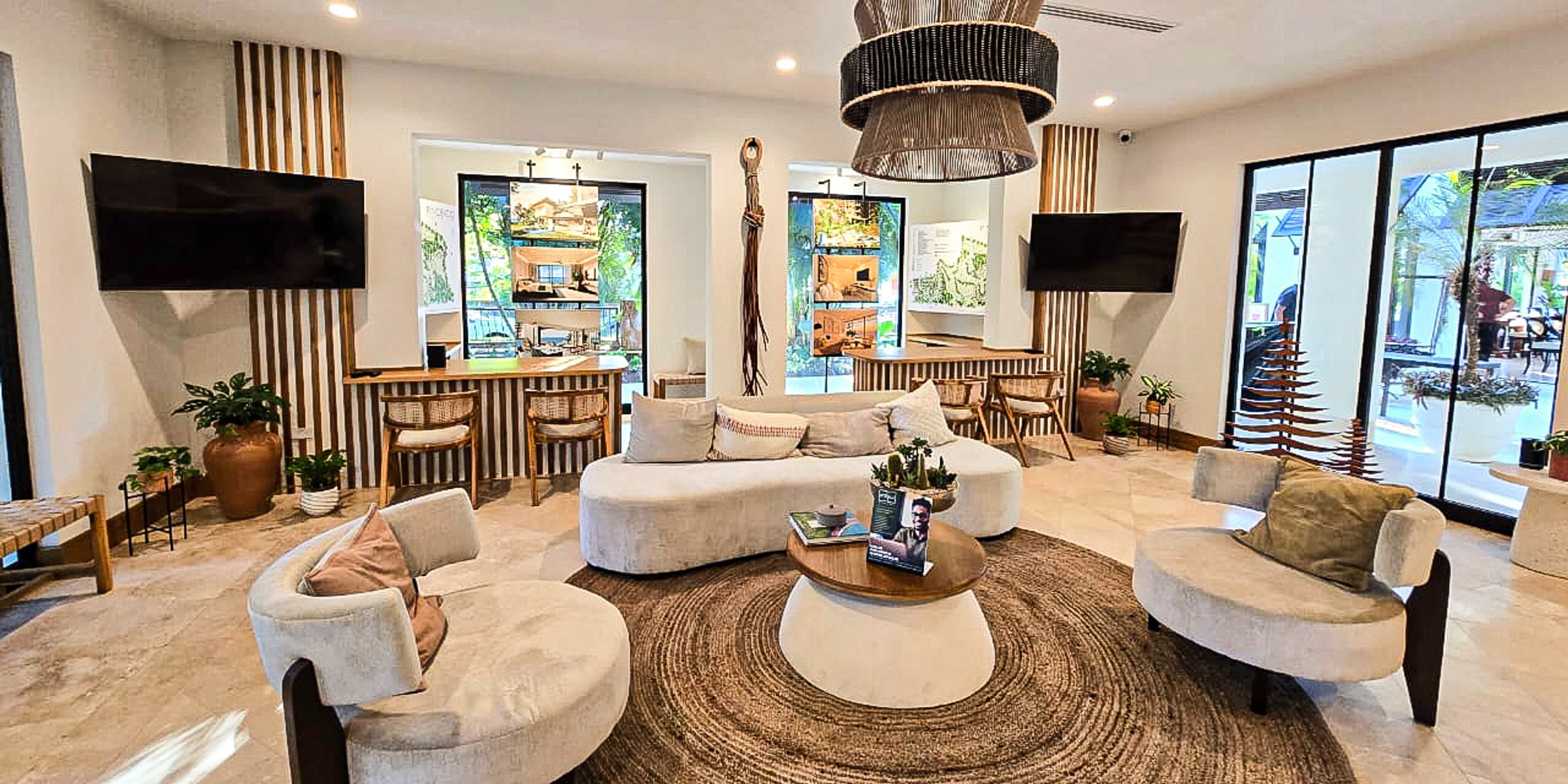 Pacifico Beach Club lounge with curved white sofas, a woven pendant lamp and a jute rug