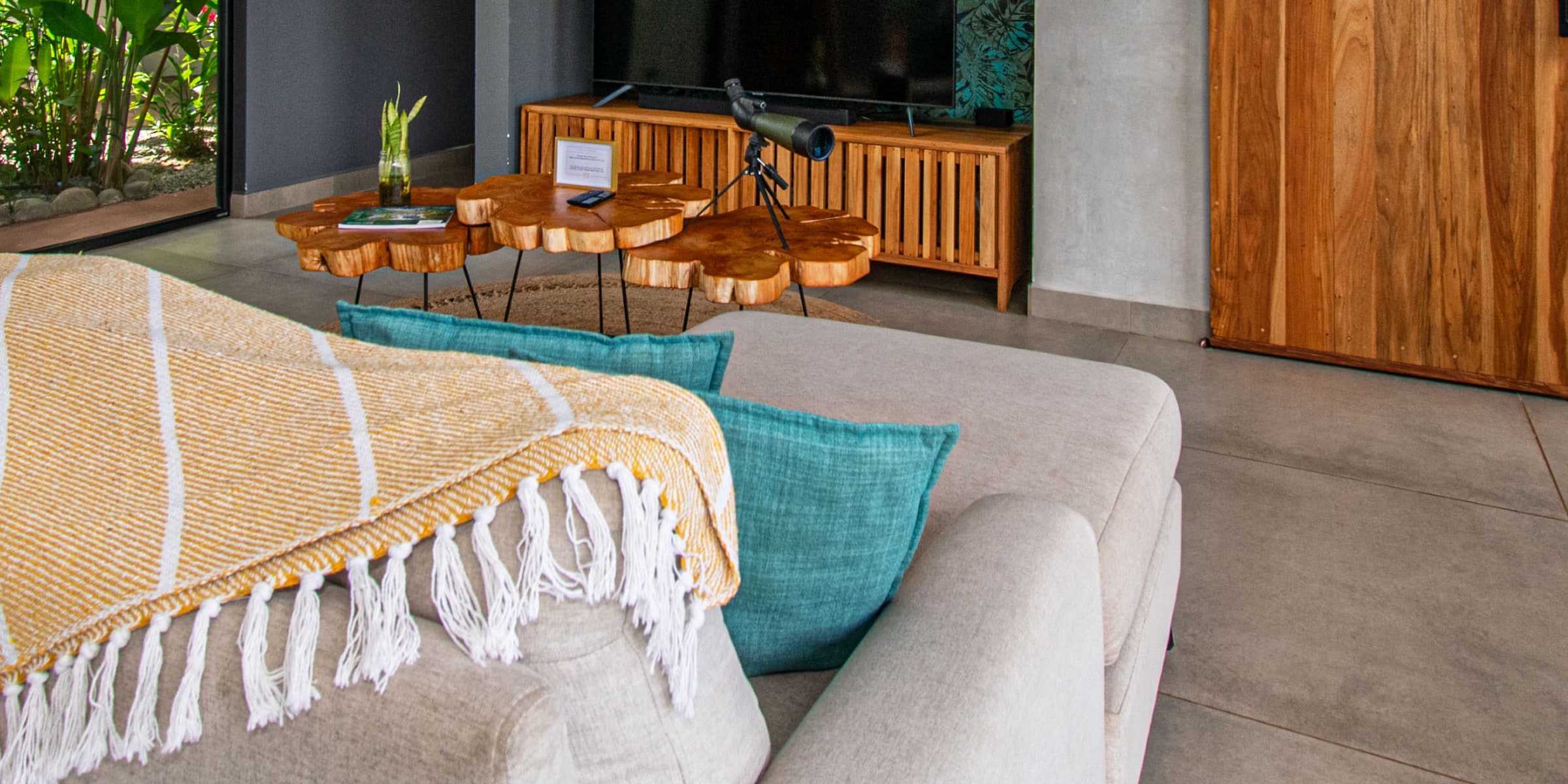 Villa Unique family room with live-edge wood tables and a striped throw