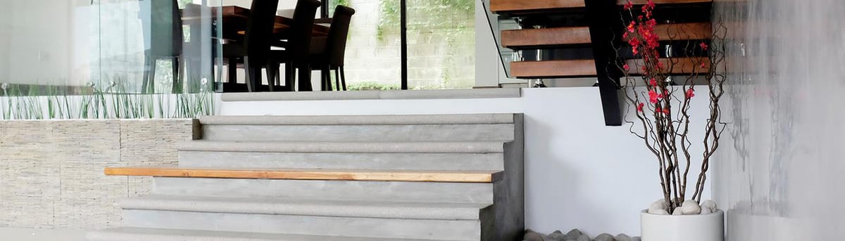 Francosta home with a floating wood staircase over a white pebble bed